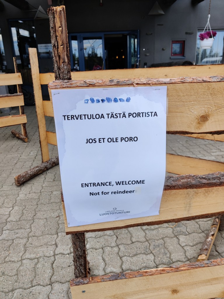 Kuva portissa olevasta lapusta, jossa lukee: "Tervetuloa tästä portista jos et ole poro. Entrance, welcome Not for reindeer."
