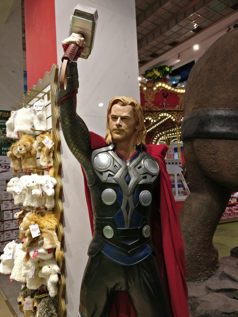 Kuva Marvel-sarjakuvien ukkosenjumala Thorista, josta on tehty patsas lelukauppaan. Hahmon ulkonäkö on otettu Thoria näyttelevältä Chris Hemsworthiltä, joten sillä ei ole kypärää päässä. Kädessään Thor kannattelee päänsä päälle vasaraansa.