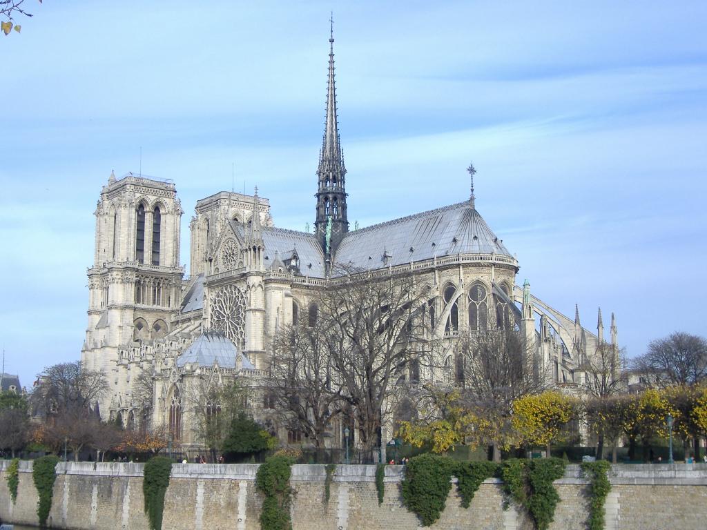 Kuva Notre-Damen katedraalista takaapäin, jolloin isot tornit jäävät hieman piiloon. Kapea keskitorni korostuu kuvan keskellä.