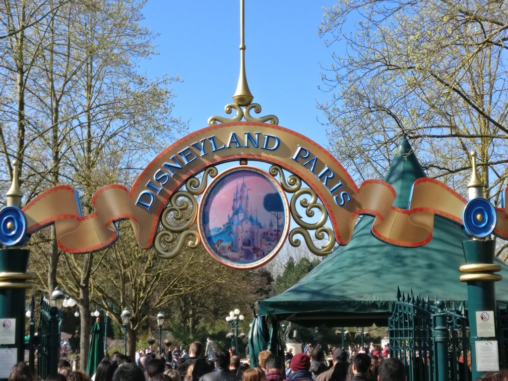 Kuva Pariisin Disneylandin portista ja ihmisjonosta sisään.