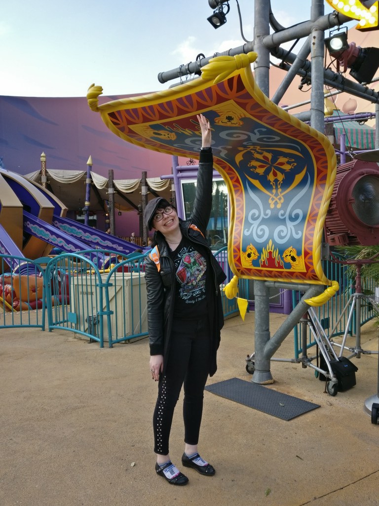 Katja virnuilee ja kurkottaa kohti Aladdinin taikamattoa.