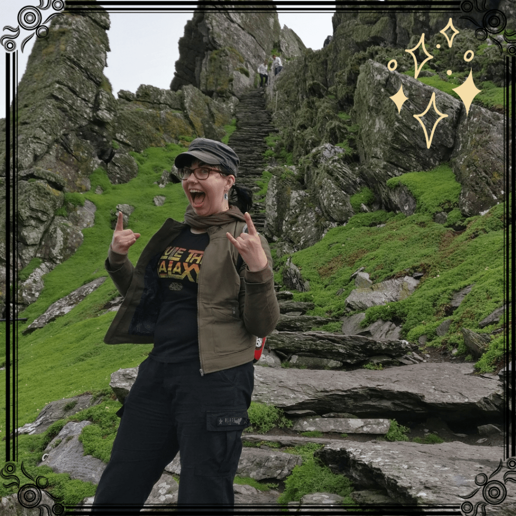 Katja poseeraa iloisena Star Wars -paita päällä kallioisen maaston edessä. Hänen takanaan nousevat kivestä asetellut rappuset korkeuksiin.