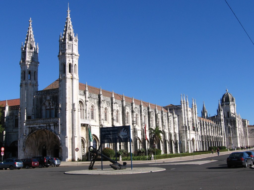 Kuvassa valtavan pitkä, vaalea rakennus, jonka päädyssä on kapeat, goottilaishenkiset tornit.