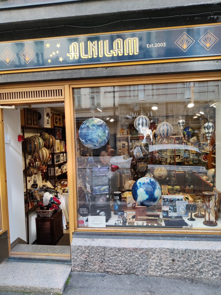 Valokuva Alnilam-kaupan näyteikkunasta, jossa korostuu erityisesti useat koristekuumailmapallot.