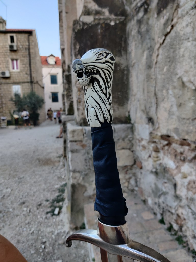 Erikoislähikuva miekasta, jonka kahvassa on valkoinen susi.