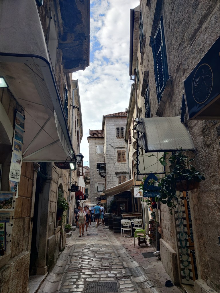 Kuva kapeasta, kivetystä kujasta, jota reunustavat kiviset talot. Pienten matkamuistomyymälöide oviaukkojen päällä on kangaskatoksia. Kauempana näkyy jokunen ihminen kävelemässä.