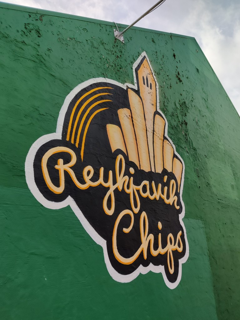 Kuvassa vihreäksi maalattu talonpääty, jossa iso seinämaalaus, jossa lukee Reykjavík Chips.