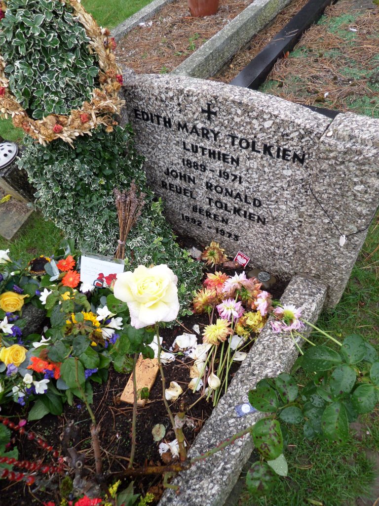 Tolkienin ja hänen vaimonsa hautakivi, jonka edessä on paljon erilaisia kukkia ja viestejä faneilta.
