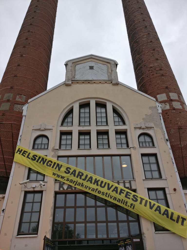 Suvilahden Kattilahallin julkisivu, jonka yli kulkee banderolli, jossa lukee Helsingin sarjakuvafestivaalit