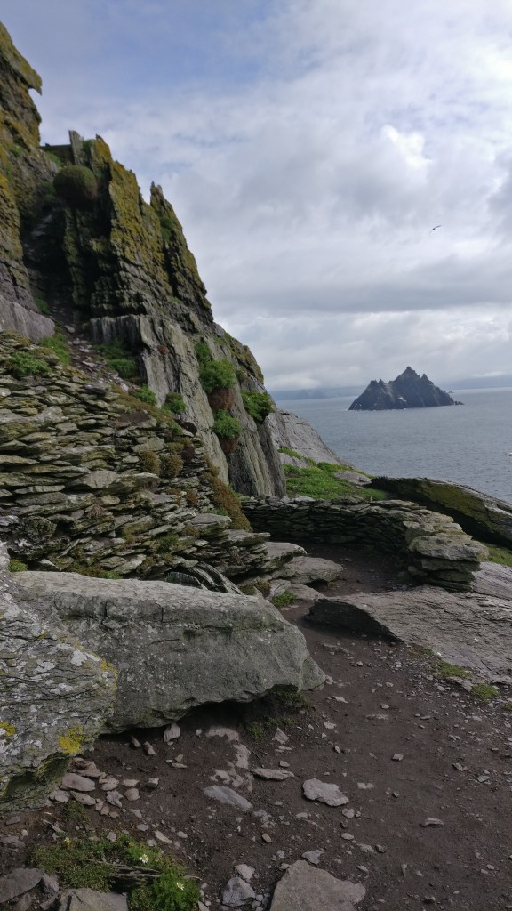 Kuva kivikkoiselta saarelta kohti merta. Kallio on sammaleen peittämää. Merellä näkyy kauempana toinen kalliosaari.