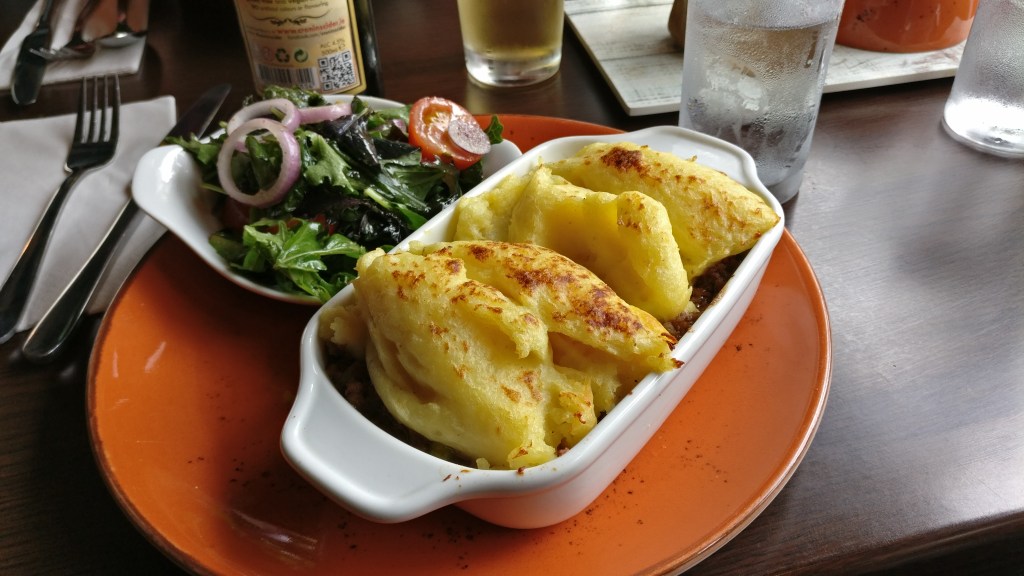 Erikoislähikuva valkoisesta vuoasta, jossa on perunamuusilla kuorrutettu shepherd's pie -ateria.