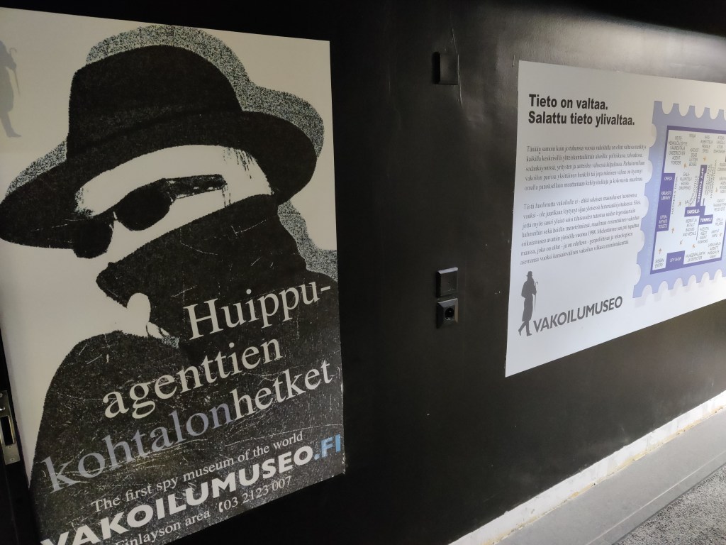 Valokuva seinästä, jossa mainostetaan Vakoilumuseota teemalla "Huippuagenttien kohtalonhetket".