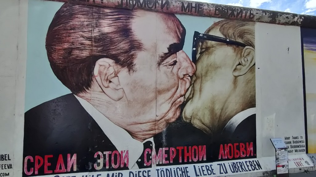 Kuvassa oleva maalaus perustuu Leonid Brežneviä ja Erich Honeckeria esittävään valokuvaan, jossa mieskaksikko suutelee keskenään.