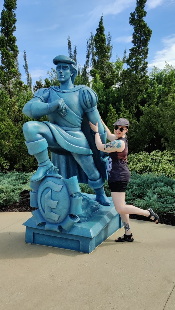 Kuvassa Katja poseeraa hymyillen prinssi Erikin patsaan vieressä. Erik-patsas on kirjaimellinen patsas, joka elokuvassa putoaa mereen laivasta.