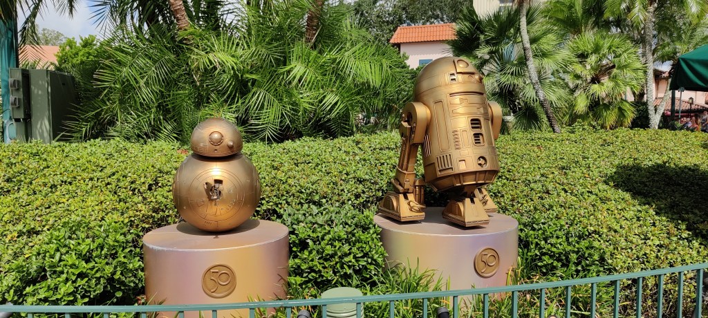 Viheralueen keskellä kaksi kultaista patsasta Star Warsin droideista BB-8 ja ja R2-D2.