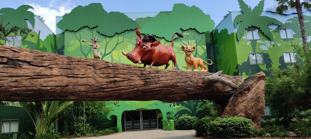 Kuvassa Leijonakuningas-elokuvasta patsaiksi rakennettu kohtaus, jossa Simba, Pumba ja Timon kävelevät puunrungolla.