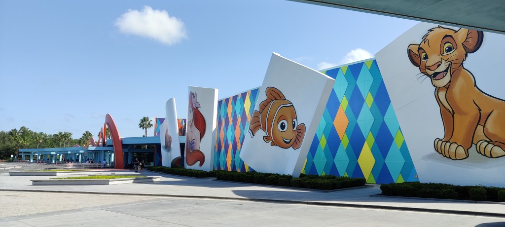 Valtavan kokoisen tasakattoisen rakennuksen seinusta, jossa on isoja maalauksia Simbasta, Nemosta, Arielista ja Autoista.