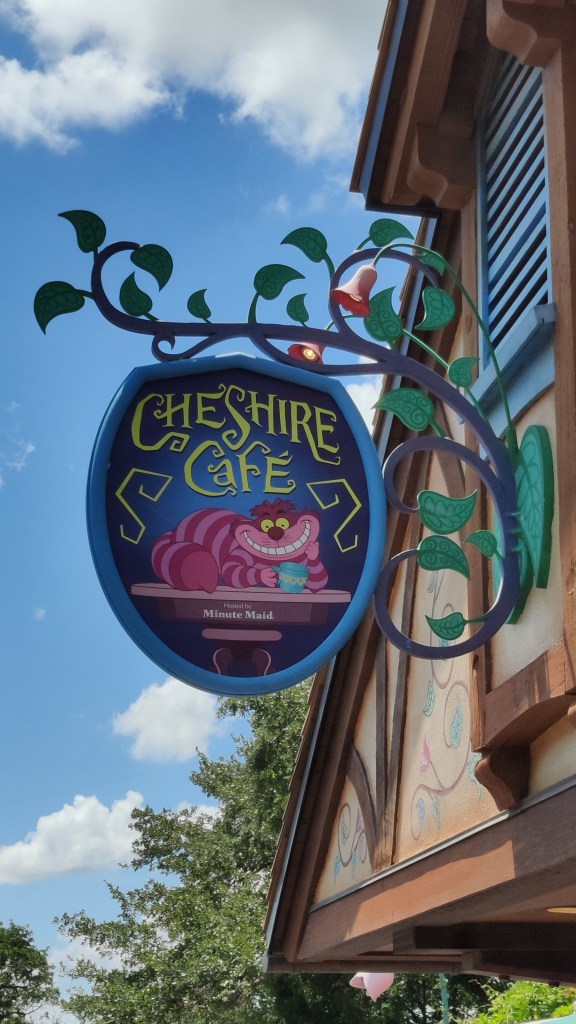 Erikoislähikuva pubikyltistä, jossa lukee Cheshire Café. Kyltissä on kuvattu Disneyn piirretyn Irvikissa, joka pitelee tassuissaan kahvikuppia.