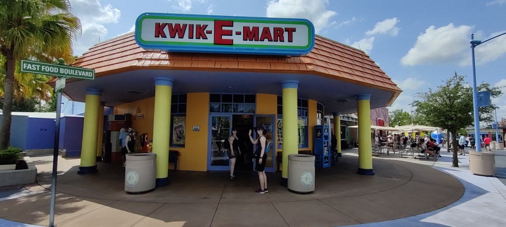 Kuvassa Simpsons-sarjasta tuttu ruokamaerketti Kwik-E-Mart, jonka edessä Tarja ja Sari moikkaavat kameraa.