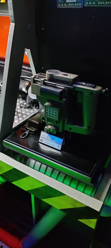 Kuvassa Aliens-elokuvasta tuttu liiketunnistin omalla tasollaan vihreän valon korostamana.