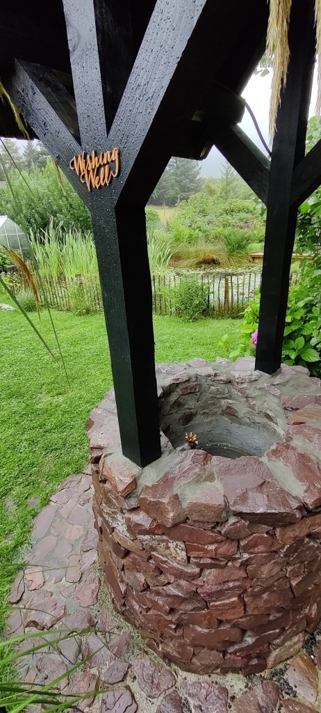 Vanha, pyöreä kaivo, jossa puinen katos. Katoksessa lukee "Wishing Well"