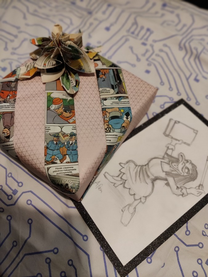 Vanhoilla Aku Ankka -lehden sivuilla koristeltu lahjapaketti, jossa on sivuista tehty ruusuke. Sen vieressä lyijykynällä piirretty kortti, jossa Milla Magia pitelee kädessään kirjaa.