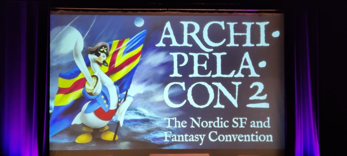 Valkokankaalle heijastettu Archipelacon 2 -teksti, jossa lukee alla The Nordic SF and Fantasy Convention. Kuvassa on tapahtuman maskottijoutsen, joka on pukeutunut merirosvoksi ja pitelee toisessa siivessään miekkaa ja toisessa Ahvenanmaan lippua.