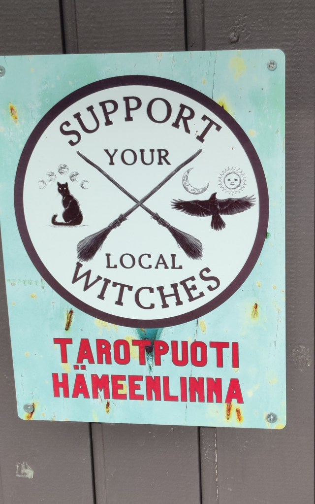 Oven pielessä oleva kyltti: Support your local witches, Tarotpuoti Hämeenlinna.
