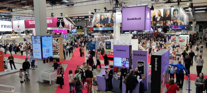 Yläviistosta otettu kuva, jossa Messukeskuksen iso sali täynnä ihmisiä Helsingin kirjamessuilla.